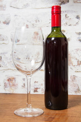 Bottle of red wine with glass ready to pour