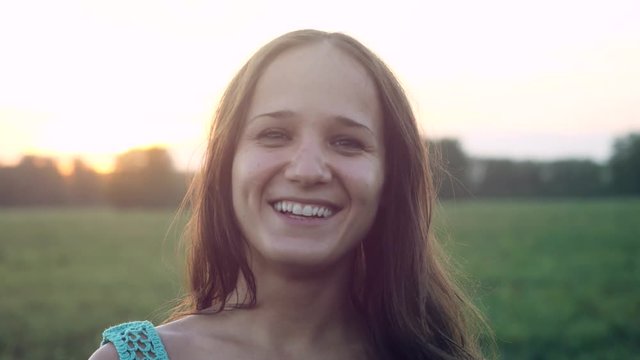 Portrait of pretty smiles woman at sunset in the field. 3840x2160