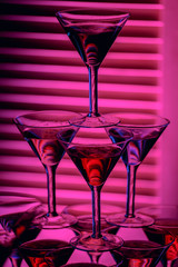 beautiful wine champagne glasse in front of colorful background with shades of pink.