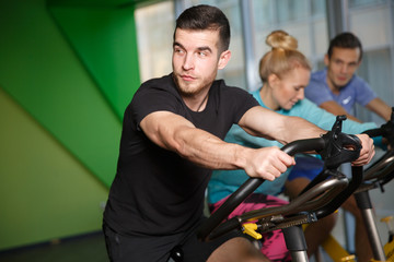 Obraz na płótnie Canvas Sports people on exercise bikes