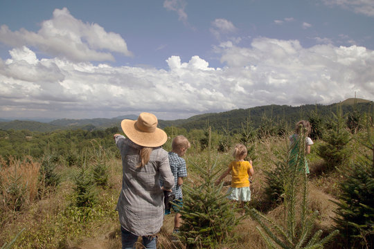 Mother and children exploring outdoors, rear view