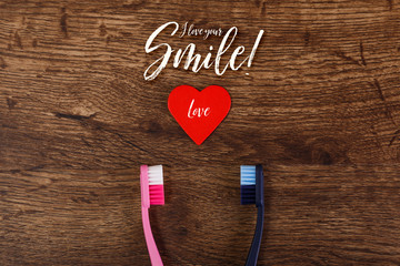 Couple love concept with heart and toothbrushes. Valentines day design on wood vintage background. Love your smile.