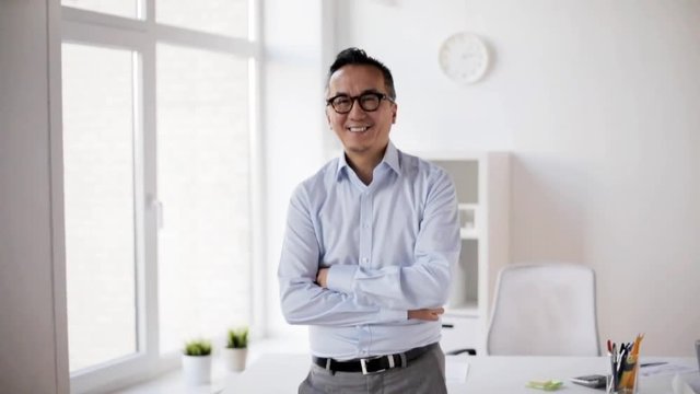 happy smiling asian businessman at office
