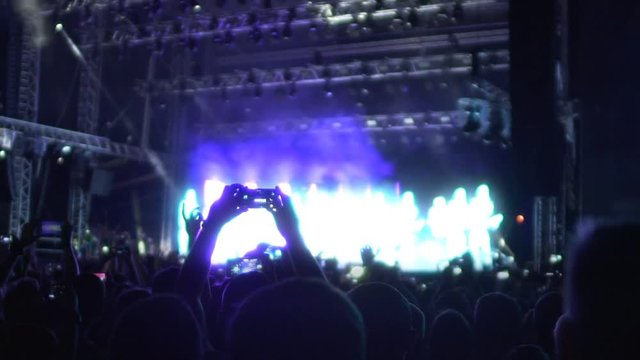 Music fans recording video of amazing performance on gadgets, concert slow-mo