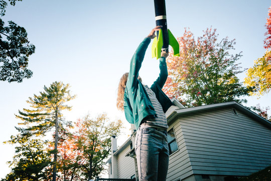 Girl throwing toy rocket upward toward blue sky