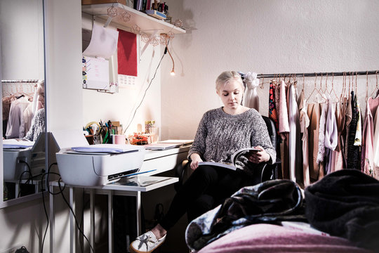 Female university student studying in the bedroom in her shared student house