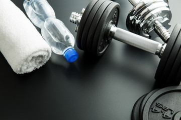 Dumbbell, bottle of water and white towel.