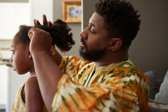 Father combing daughter