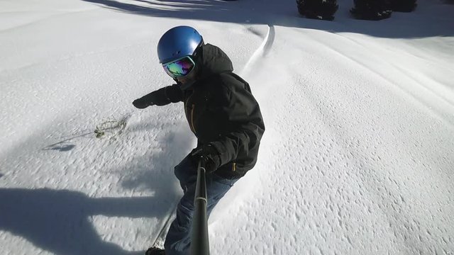 Close up of extreme snowboarder riding by powder by GoPro