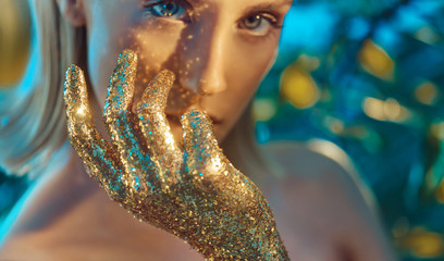 Pretty blond woman with golden, glittering hands