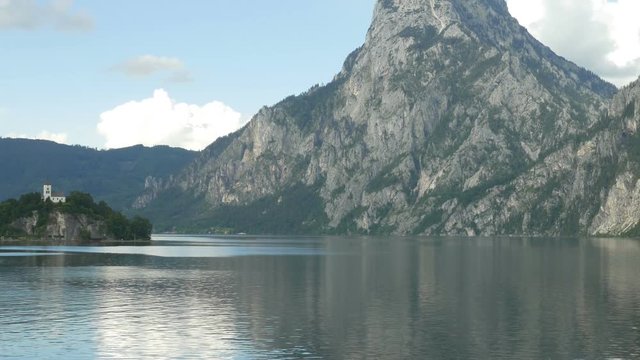 Zoom out of Johannesberg Chapel on Traunsee in Traunkirchen, Upper Austria, Austria, with Traunstein in the background.