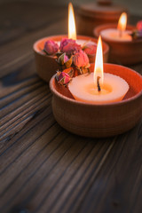 Obraz na płótnie Canvas Peach small candles in wooden cups with dried flowers