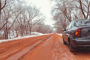 lonely car road in snow red because of ore