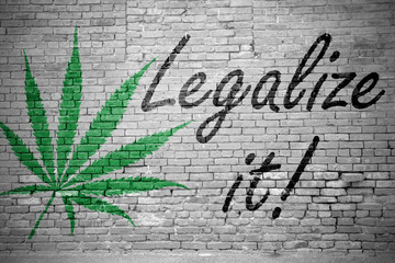 Hanfblatt Legalize It! an Ziegelsteinmauer