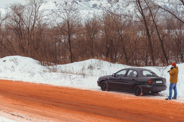 lonely car road in snow red because of ore