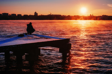 fisherman on the dock at sunset