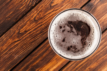 glass of beer on an old wooden table. top view
