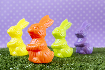 Lots of colorful Easter bunnies on the artificial grass.