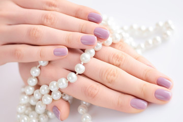 Hands of a woman with pink manicure on nails and pink flowers