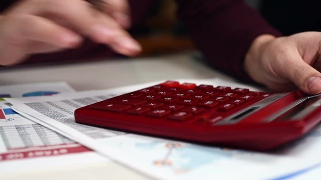 Trader Hand Using Red Calculator. Business Concept. Close Up