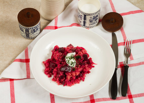 Risotto with beetroots, beets. Beige background, white plates.