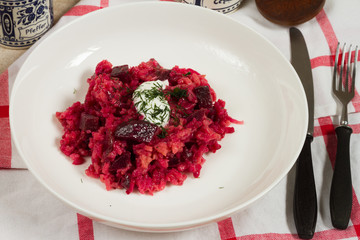 Risotto with beetroots, beets. Beige background, white plates.