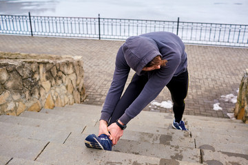 Athlete man warming up before running. Sport life spring winter.