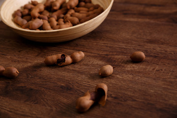 Sweet tamarind on grunge rustic wood background. Natural organic diet food with a lot of vitamins. Plate dish or bowl on wooden board.