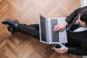 Businessman sitting on the floor with his pc