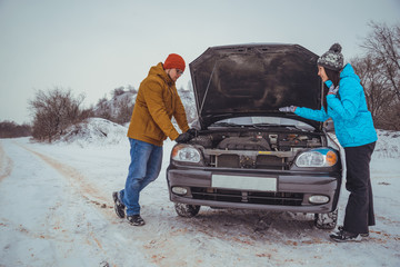 couple on the road with broken car