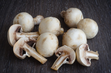 Fresh mushrooms champignons on wooden background.