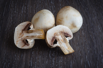 Fresh mushrooms champignons on wooden background.