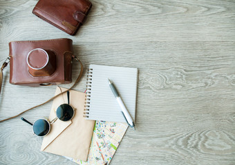 camera, a map, and sunglasses on the table. Going on a trip, to prepare for release.