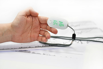 Blood oxygen meter on mans finger.