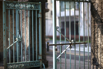 Heavy metal wrought-iron gates of the botanical garden with exit to city street