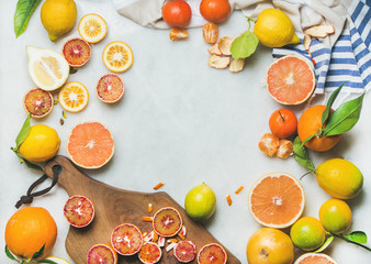Natural fresh citrus fruits on wooden rustic board over grey marble table background, top view, copy space