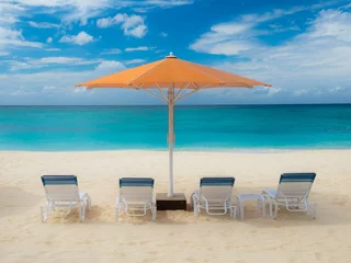 Photo sur Plexiglas Plage de Seven Mile, Grand Cayman Parasol and sun loungers on Seven Mile Beach in the Caribbean, Grand Cayman, Cayman Islands