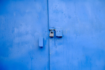 Big metal door blue dark paint and dark lock.