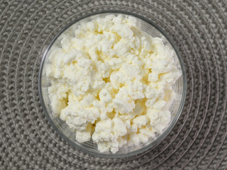 The cheese in the container on the table.