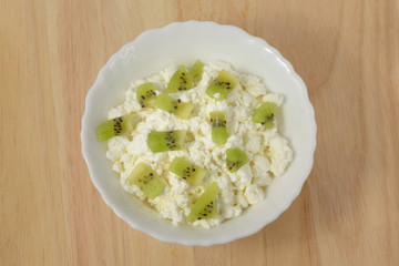 Soft cheese with pieces of fruit, kiwi.