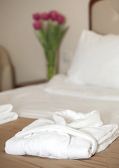 Fototapeta na wymiar white bathrobe on the bed