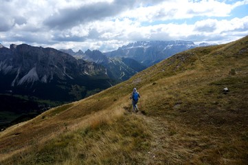Wanderin unterwegs auf Bergwiese in traumhafter Bergkulisse in Gröden / Südtirol