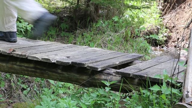 Trekking on wooden bridge over the mountain creek