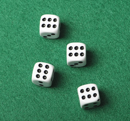 Four white dice with number six on green background. Horizontal shoot.