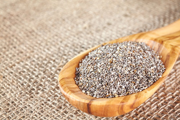 Close up picture of Chia seeds in a wooden spoon, selective focus.