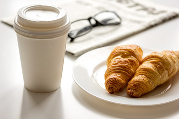 Breakfast for businessman with coffee and croissant on white table