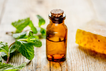 organic cosmetics with herbal extracts of mint on wooden background