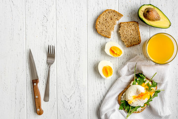 sandwich with poached eggs on wooden background top view mockup