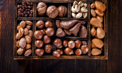 Nuts Mixed in a Wooden Vintage Box.Assortment, Walnuts,Pecan,Peanuts,Almonds,Hazelnuts,Macadamia,Cashews,Pistachios.Concept of Healthy Eating.Vegetarian.selective focus.