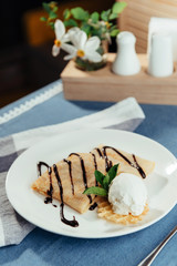 Pancakes with ice cream and chocolate sauce.